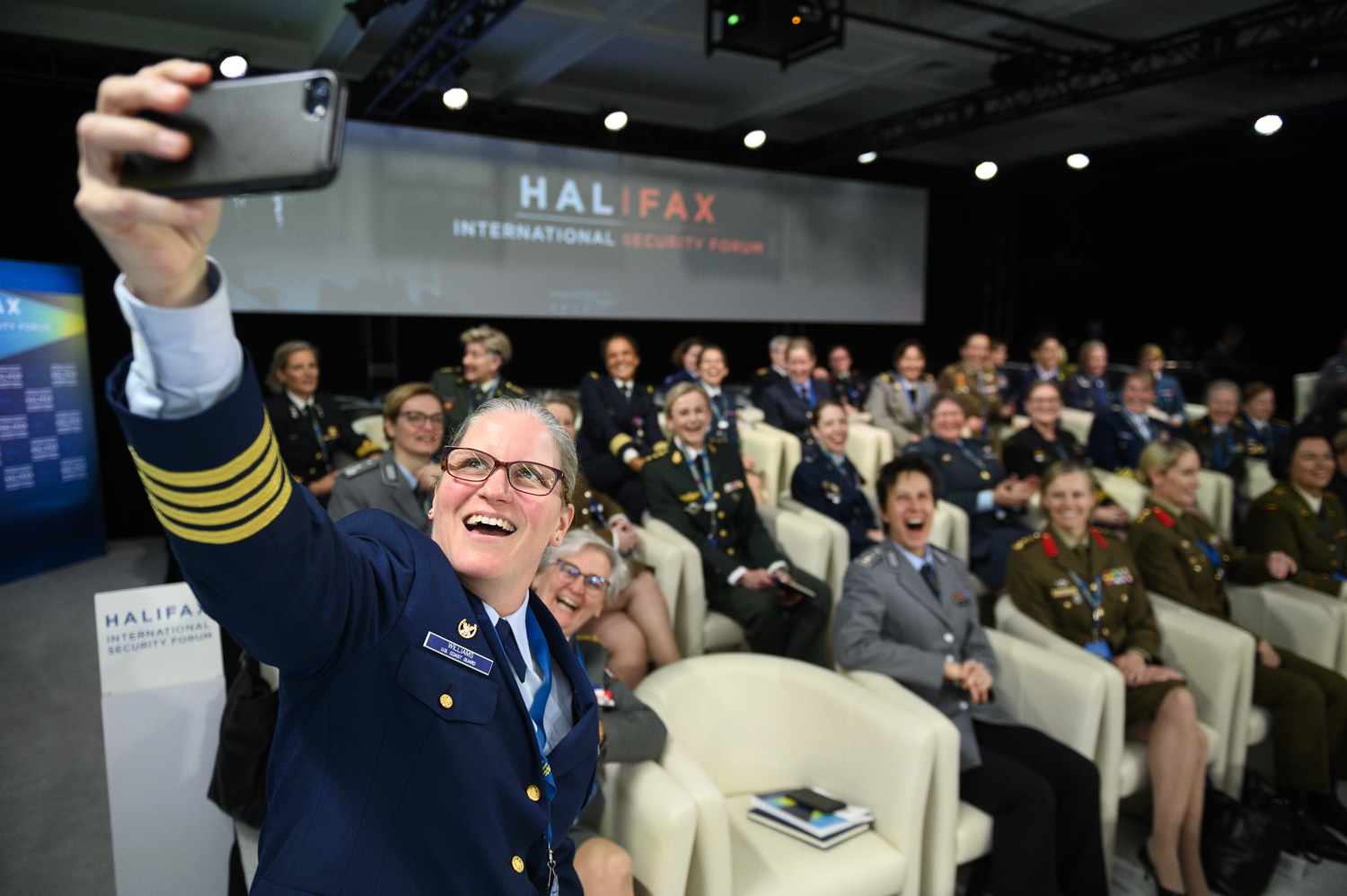 A conference presenter taking a selfie with an audience